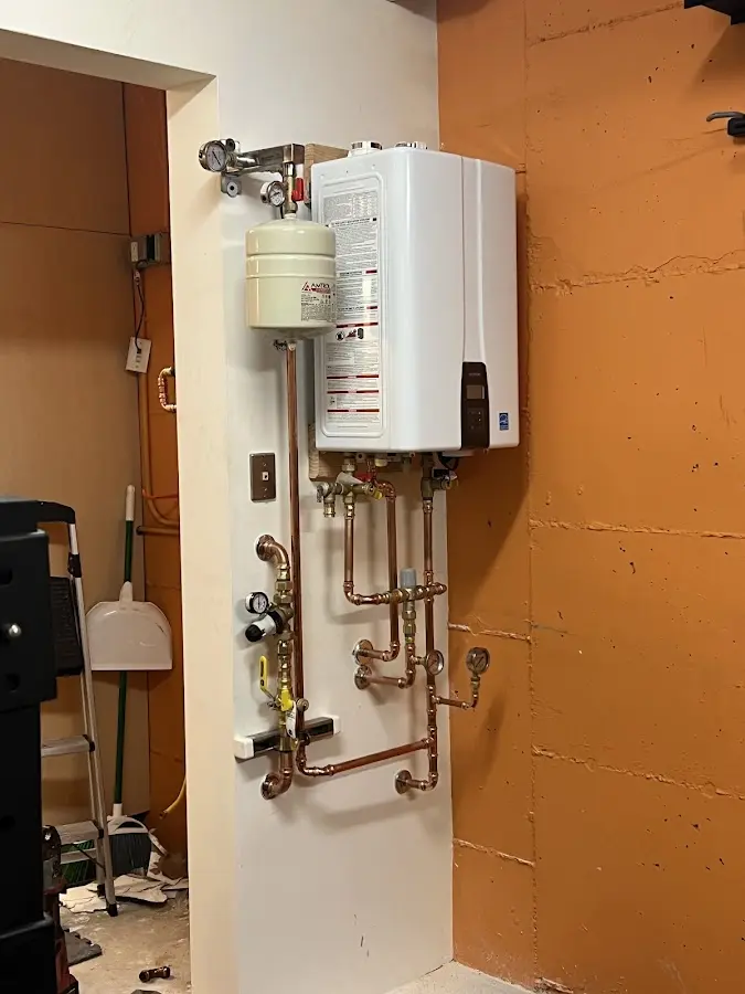 Plumbing technician inspecting water heater connections in Meadville